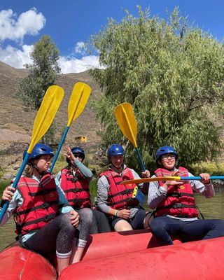 Grupo con casco y chaleco levantando los remos antes del rafting