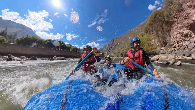 Raft crossing a rapid on the Urubamba under the sun