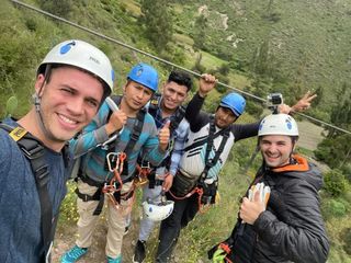 Smiling group in harnesses and helmets before the zipline